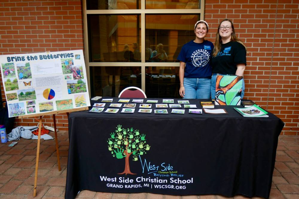 West Side Christian Teachers stand by table and poster about butterflies